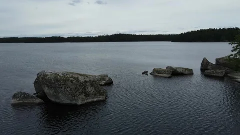 Drone flight passing two rocks over a lake in Sweden. Stock Footage 248098956