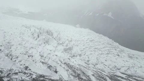Drone flight revealing the glacial ice patterns and rocky moraine edges of Stock Footage 342661749