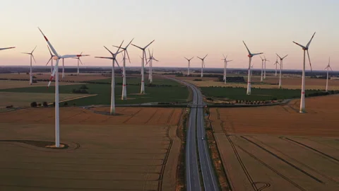 Drone flight to the right over a large field with many wind turbines spinning. Stock Footage 163099727