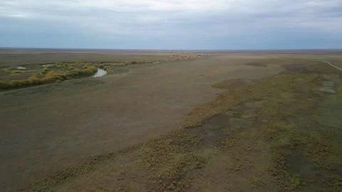 Drone flight rising along dirt road revealing wide Kazakh steppe Stock Footage 334329900