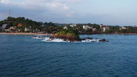 Drone flight rising from sea level towards Parrot Rock in Mirissa Stock-Footage 316747199