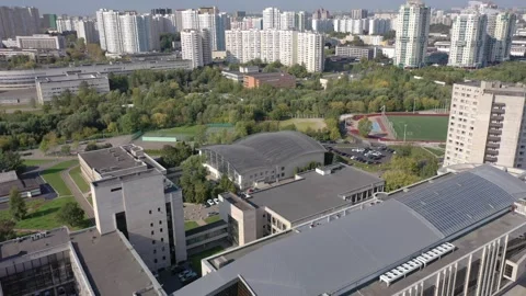 Drone flight rotating left beside campus complex Vidéo 324874137