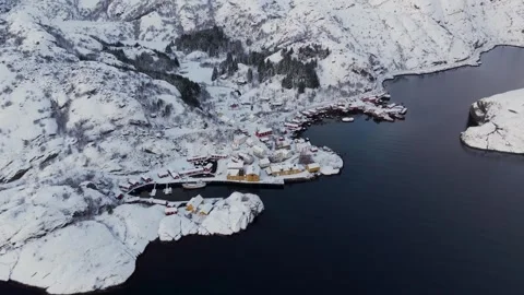 Drone flight showcases the snowy charm of Nusfjord Fishing Village, Fjord, and Stock Footage 257865622