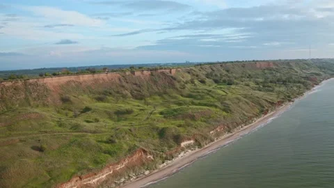 Drone flight at sunrise, surrounded by turquoise green sea and mountain slope Stock-Footage 130403288