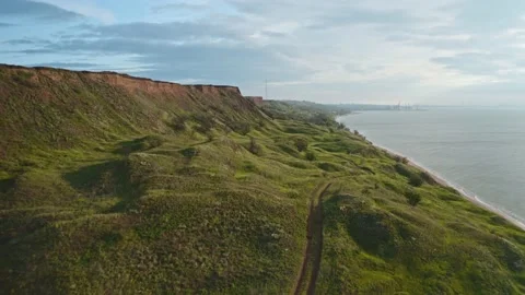 Drone flight at sunrise, surrounded by turquoise green sea and mountain slope 스톡 동영상 130403367