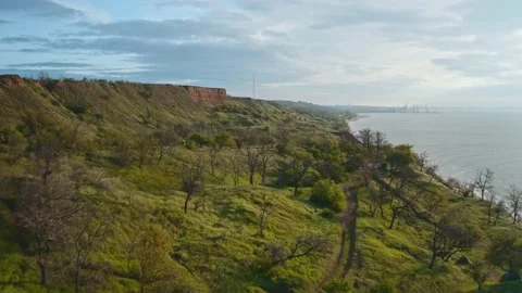 Drone flight at sunrise, surrounded by turquoise green sea and mountain slope Video stock 130403368