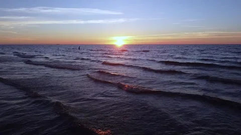 Drone flight at Sunset over sea with ducks wading and man going to swim Video stock 311867620