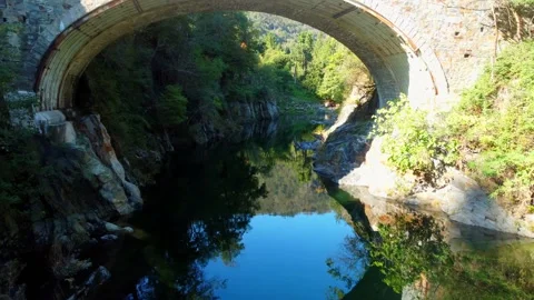 Drone flight through a bridge over a river in the mountains Vidéo 237162560
