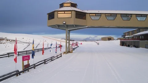 Drone flight through cross-country ski resort start area with tracks in snow Stock Footage 121581390