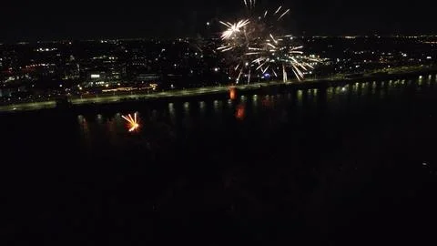 Drone flight through holiday fireworks above water with reflection on the black Fotos Stock