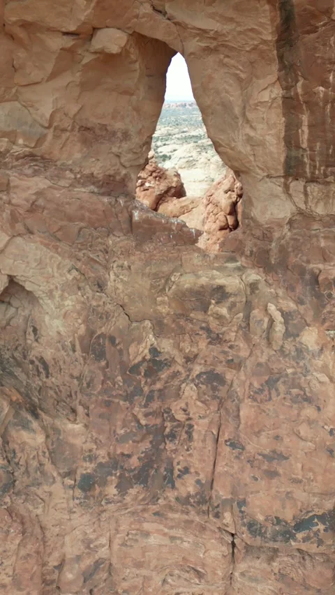 Drone flight through natural rock arch in desert canyon Stock Footage 305340268