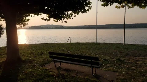 Drone flight through a small park and over Lake Biel at sunrise Stock Footage 139981458