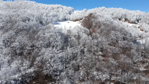 Drone flight toward the peak of the mountain with cross on the ridge in winter Stock Footage 149370482