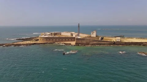 Drone flight towards the lighthouse San Sebastian on a rocky island. Stock Footage 134671384