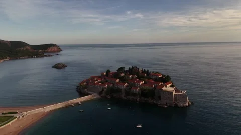 Drone Flight Tracking Sveti Stefan Coastline toward Beach Causeway, 4K Vídeos de archivo 337179683