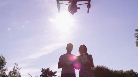 Drone Flight With Two Pilots In Silhouette With Sun Flare In Slow Motion Stock Footage 82580416