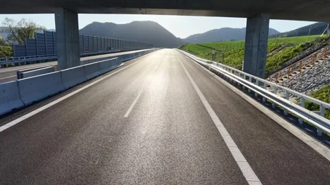 Drone flight under highway bridge above empty motorway in green landscape Stock Footage 335070049