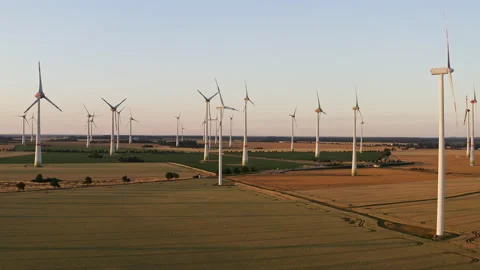 Drone flight upwards over a large field with many wind turbines spinning in a Stock Footage 163097125