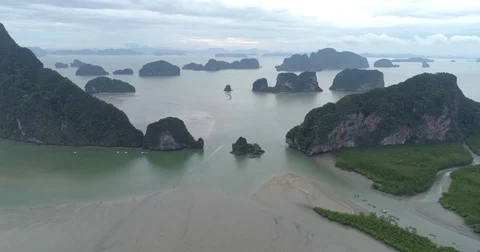 Drone flight video under many rocky islands in a calm Phang Nga bay at sunrise Stock Footage 76283881