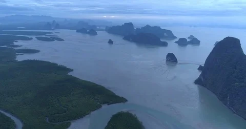 Drone flight video under many rocky islands in a calm Phang Nga bay at sunrise Stock Footage 76283923