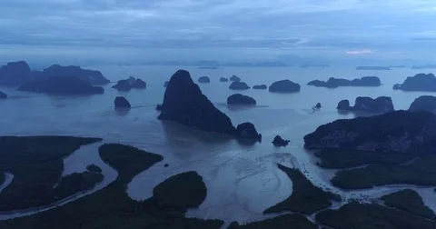 Drone flight video under many rocky islands in a calm Phang Nga bay at sunrise Stock Footage 76284056