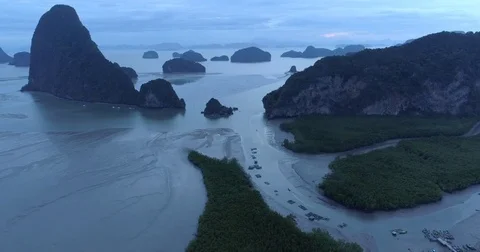 Drone flight video under many rocky islands in a calm Phang Nga bay at sunrise Video stock 76284149