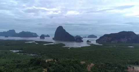 Drone flight video under many rocky islands in a calm Phang Nga bay at sunrise Video stock 76284211