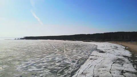 Drone flight with a view of the sandy beach and the sea in the melting ice. Stock Footage 133763085