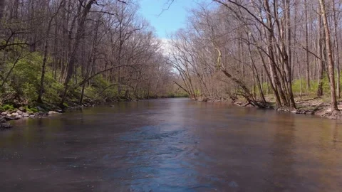 Drone floating down a stream early spring Stock Footage 135950371