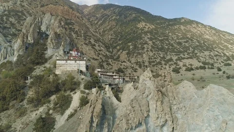 Drone fly above harsh crests cliffs to secluded highland Braga monastery, Nepal Stock Footage 124679737
