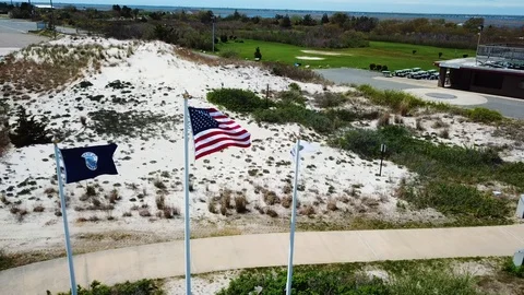 Drone fly around American flag waving with beach background Stock Footage 107676785