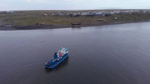 Drone fly behind a ship that approaches the shore Stockbeeldmateriaal 99965871