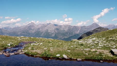 Drone fly over Alpine lake in the Italian Alps with surrounding mountains Видео 319180635