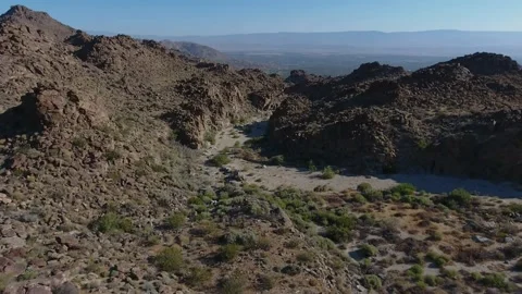 Drone fly over Blue Sky rocky  Desert Mountain Wash Stock Footage 148509321