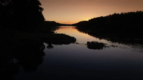 Drone fly over glassy river at dusk slow motion river bank Stock Footage 63972578