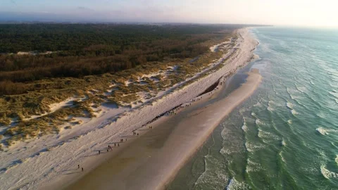 Drone fly over a large group of people running on a beautiful beach in Denmar Stock Footage 314213210