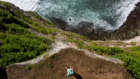 Drone fly over man stays on clifftop above ocean Stock Footage 154226598
