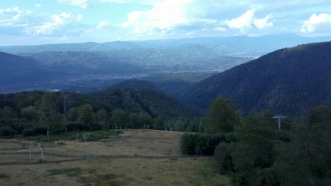 A drone fly over mountains and approaches a small village Video stock 229805973