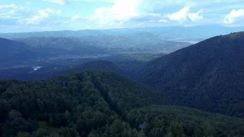 A drone fly over mountains and approaches a small village Video stock 229806001