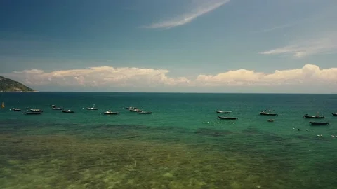 Drone Fly over pristine and calm sea with floating fishing boats on a sunny day. Stock Footage 139325115