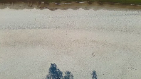 Drone fly up over sandy beach with summer inscription on the sea coast Video stock 154716566