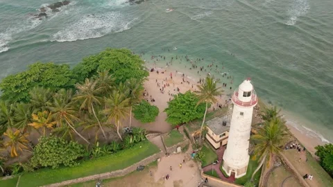 Drone fly over view of Sri Lankans enjoying a swim in the ocean near the ic.. Stock-Footage 309671797