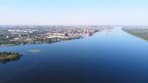 Drone fly over waving river of blue color surrounded by local village with va Stock Photos