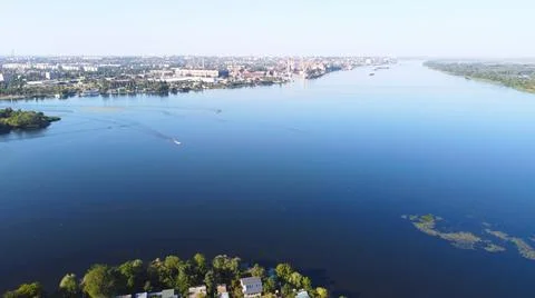 Drone fly over waving river of blue color surrounded by local village with va Stock Photos
