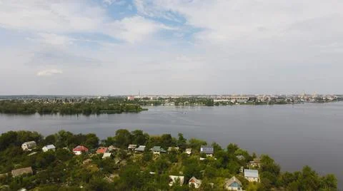 Drone fly over waving river of blue color surrounded by local village with va Stock Photos