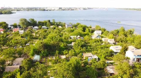 Drone fly over waving river of blue color surrounded by local village with va Stock Photos