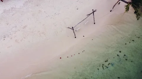Drone fly over a white sand beach with starfishes and waves brushing the shore. Stock Footage 148244635