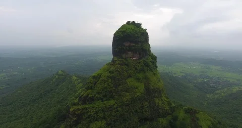 Drone fly by shot of a mountain in a lush green forest Stock Footage 117091047