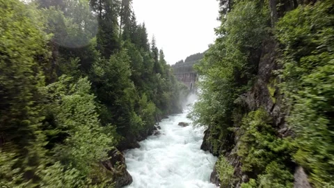Drone fly through a high stream river ending up on a waterfall dam verwallsee  Stock Footage 278875289