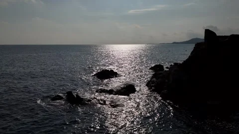 Drone fly-through over reefs toward shimmering sea path Stock Footage 321346080
